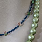 Naszyjnik składający się z dwóch sznurów z wisiorem z zielonym agatem w kształcie serca i szklanymi koralikami w odcieniach zieleni i granatu. - Szklane, granatowe koraliki