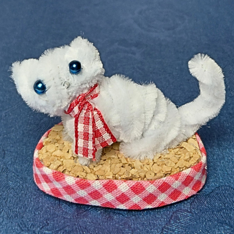 Biały kotek na korkowym podeście