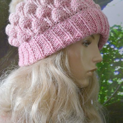 Czapka bąblowa z pomponem w kolorze różowym.