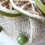 Zielona świeca wśród limonek i koralików - 