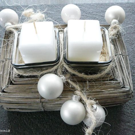 Białe świece w wiklinowym koszu