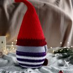 Krasnal świąteczny 50 cm, Maskotka skrzat pod choinkę, Dekoracja świąteczna - Kolorystyka: czapka w kolorze nasączonym czerwonym z bordowym brzegiem, rękawiczki w kolorze bordowym, ciemno fioletowe spodnie w białe paski, czekoladowe buciki oraz jasnoszara koszula.
