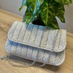 Torebka pleciona w jodełkę w kolorze białym z srebrnym akcentem - Torebka w pełnej okazałości, podkreślająca elegancję i jakość wykonania.