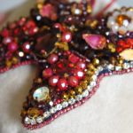 broszka z motylem z koralików w kolorze bordowym - Wykonana z drobnych koralików, większych kryształków oraz szklanych dzetów.