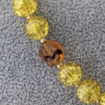 Naszyjnik z wisiorkiem z zielono - brązowego jaspisu w towarzystwie szklanych żółtych kulek i szklanych, brązowych ślimaczków - Szklane koraliki