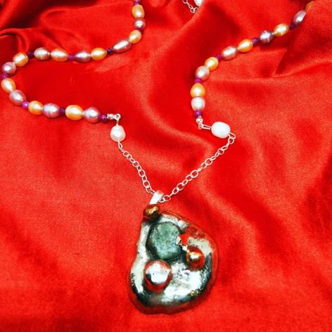 Srebrny naszyjnik z pereł i rubinów z zawieszką z surowym szafirem. 