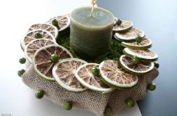 Zielona świeca wśród limonek i koralików