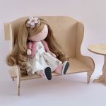 Lalka w letniej sukience i kwiatem we włosach - Lalka siedzi na ławce