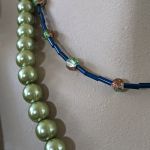 Naszyjnik składający się z dwóch sznurów z wisiorem z zielonym agatem w kształcie serca i szklanymi koralikami w odcieniach zieleni i granatu. - Szklane koraliki w kolorze zielonym