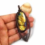 Duży wisior z labradorytem miedziany żółty - wisior na dłoni