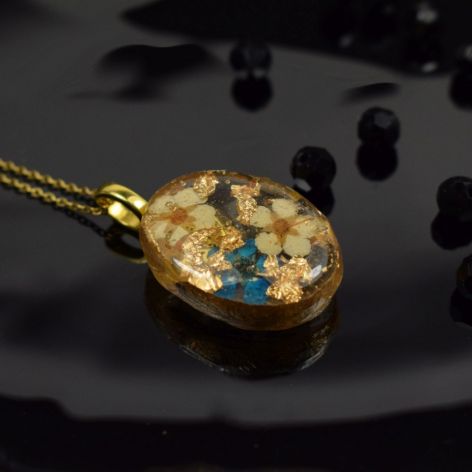 Owalny wisiorek z żywicy z kwiatuszkami i złotymi płatkami