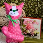 Kotek torebkowy - Kinia - 25 cm - Uszyty z pięknej bawełny różowej w białe kropeczki z zielonymi dodatkami  Pyszczek ma wyszyty ręcznie. Na brzuszku ma podwinięty ogonek.