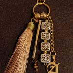 Ozdobna zawieszka do torby w kolorach złota i beżu - Ozdobna zawieszka do torby w kolorach złota i beżu