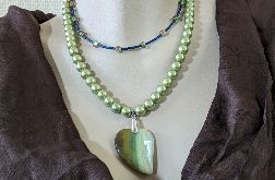 Naszyjnik składający się z dwóch sznurów z wisiorem z zielonym agatem w kształcie serca i szklanymi koralikami w odcieniach zieleni i granatu.