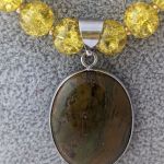 Naszyjnik z wisiorkiem z zielono - brązowego jaspisu w towarzystwie szklanych żółtych kulek i szklanych, brązowych ślimaczków - Wisior