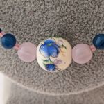 Naszyjnik w odcieniach koloru niebieskiego z koralików z jadeitu oraz z ozdobnym koralikiem z ceramiki - Zbliżenie