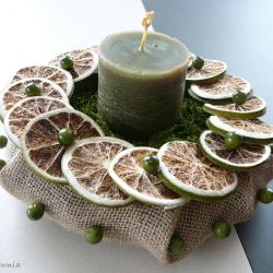 Zielona świeca wśród limonek i koralików